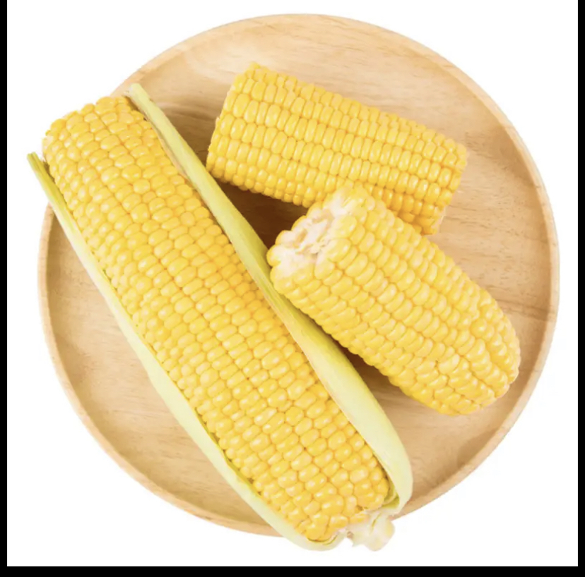 一整根蒸熟的甜玉米,金黄色玉米粒饱满湿润,表面微微反光,放置在浅色木制托盘上,背景有新鲜薄荷叶和柠檬切片,营造健康清新的饮食氛围 蒸熟的甜玉米摆放在木质餐盘上,旁边搭配绿色香草和柠檬片