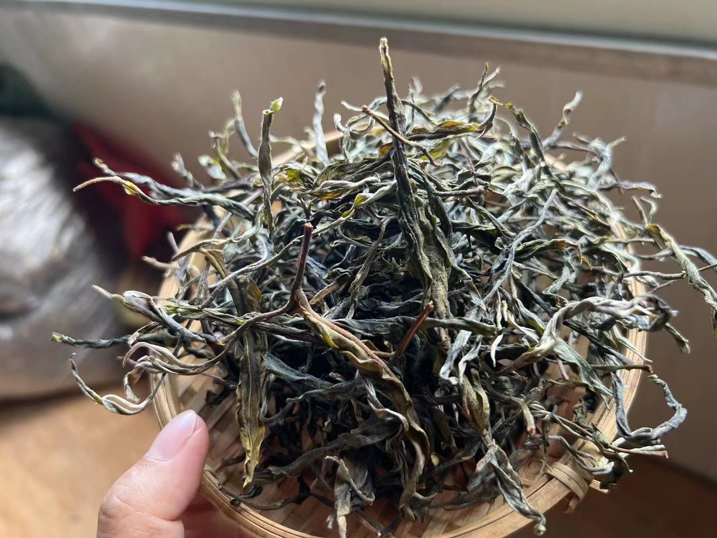 图片说明:新鲜绿色青提与干制普洱茶叶并列摆放,背景为木质桌面,光线柔和自然 青提与普洱茶原料展示图