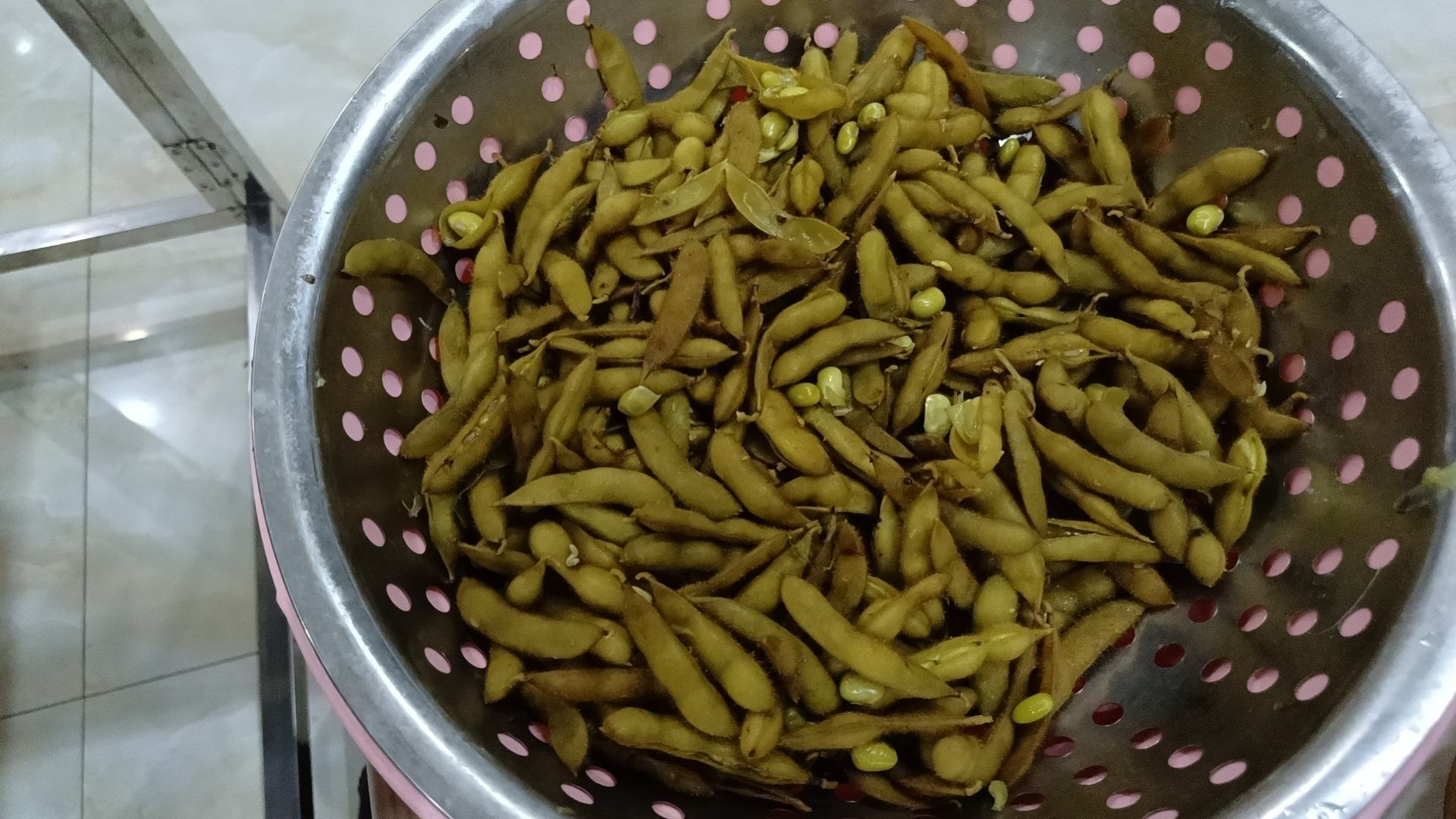 展示毛豆在沸水中焯烫的过程,锅中冒着热气,毛豆正在翻滚 毛豆焯水过程