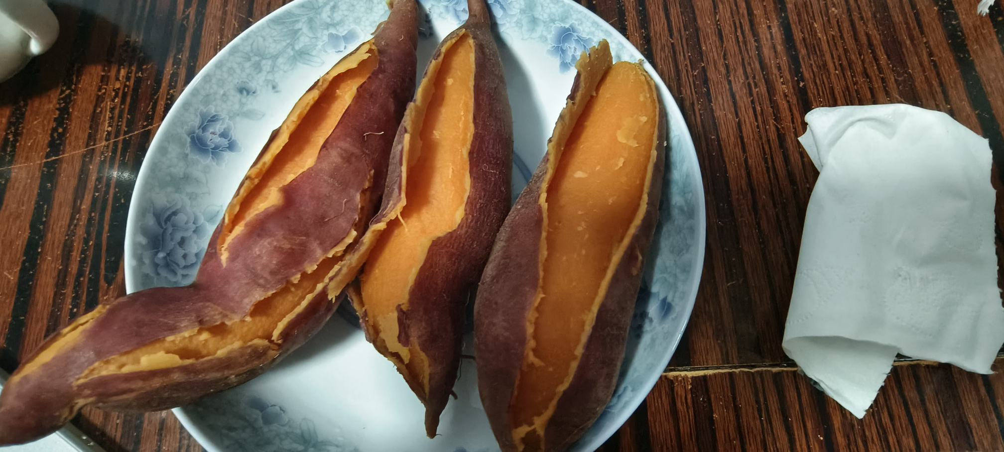 几块刚出锅的烟薯25,呈金黄色,表面微微湿润,部分边缘略带透明胶质感,整齐摆放在白色瓷盘中,背景虚化,体现食物温暖质感 蒸好的烟薯25块状成品展示