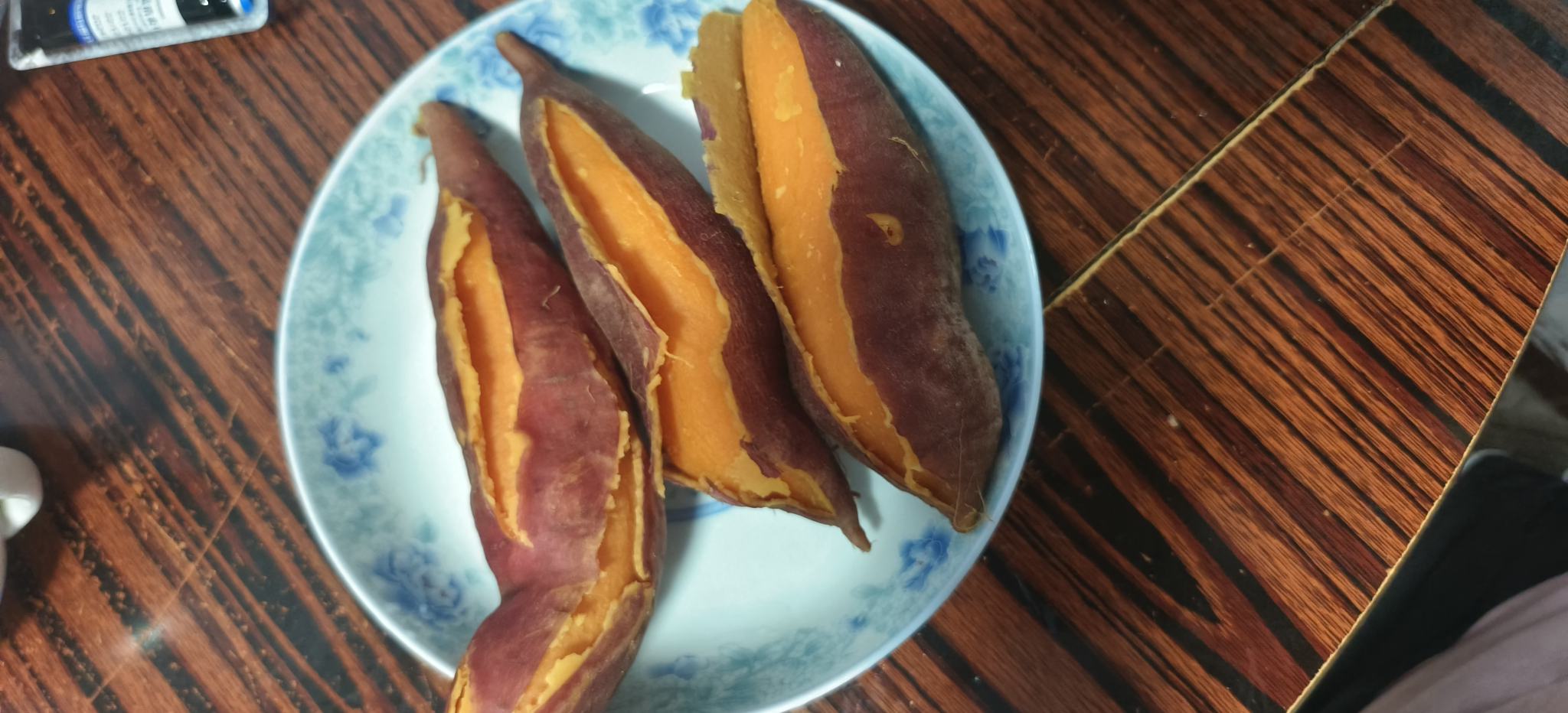 一盘刚蒸好的烟薯整齐摆放于白色瓷盘中,外皮微裂,散发热气,旁边配有计量秤显示重量为150克,背景为现代厨房台面,体现健康烹饪理念 家庭厨房中蒸熟的烟薯摆盘场景