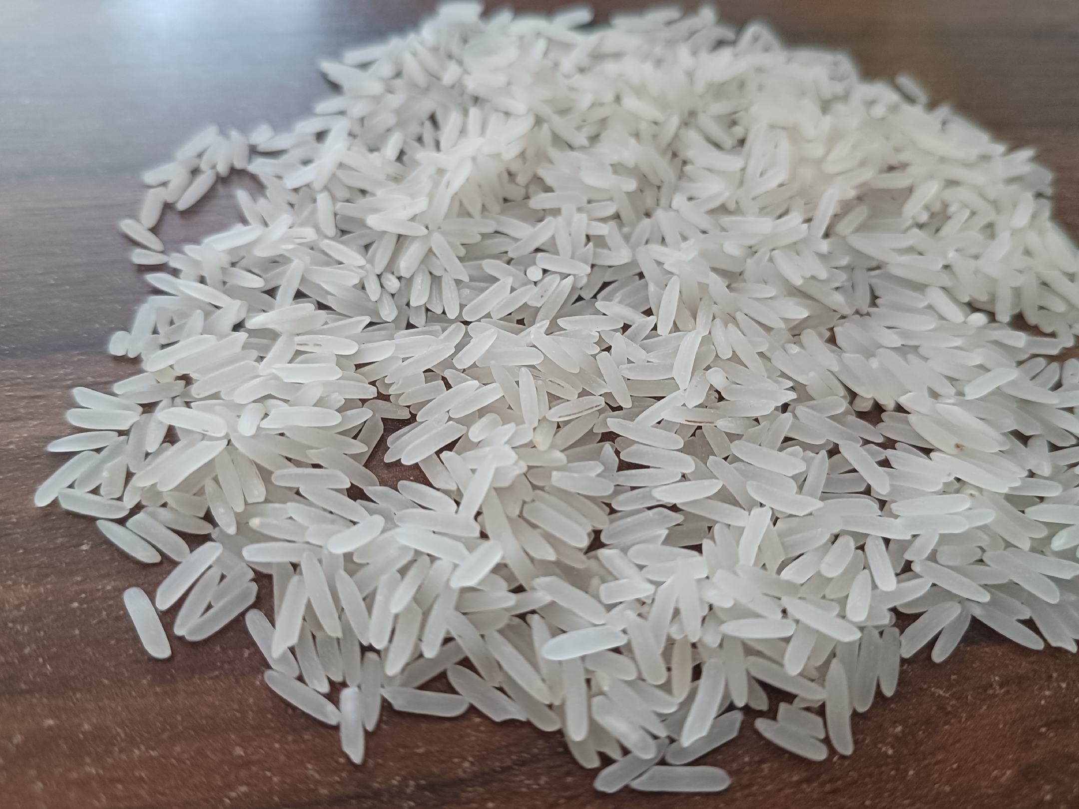 一组精致的大米包装盒摆放在木质桌面上,背景为温暖的家庭厨房环境,展现出现代生活中的品质感 寒育长粒香大米包装展示图