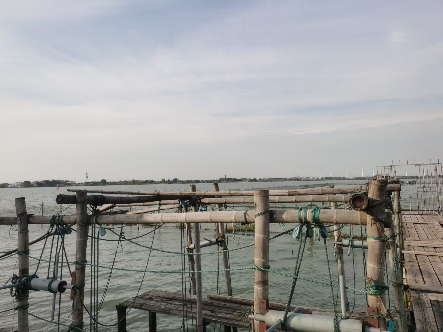 阳澄湖边的养殖场，湖面波光粼粼，渔民正在捕捞大闸蟹