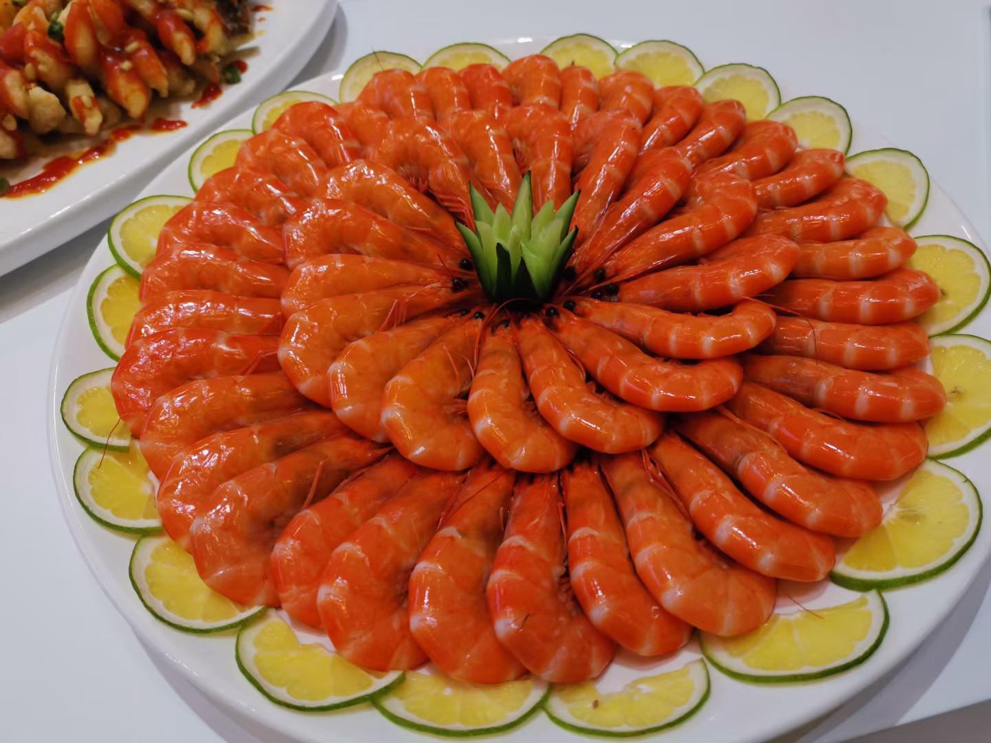 一盘金黄诱人的柠檬炒虾仁,点缀着柠檬片和葱花 柠檬炒虾仁