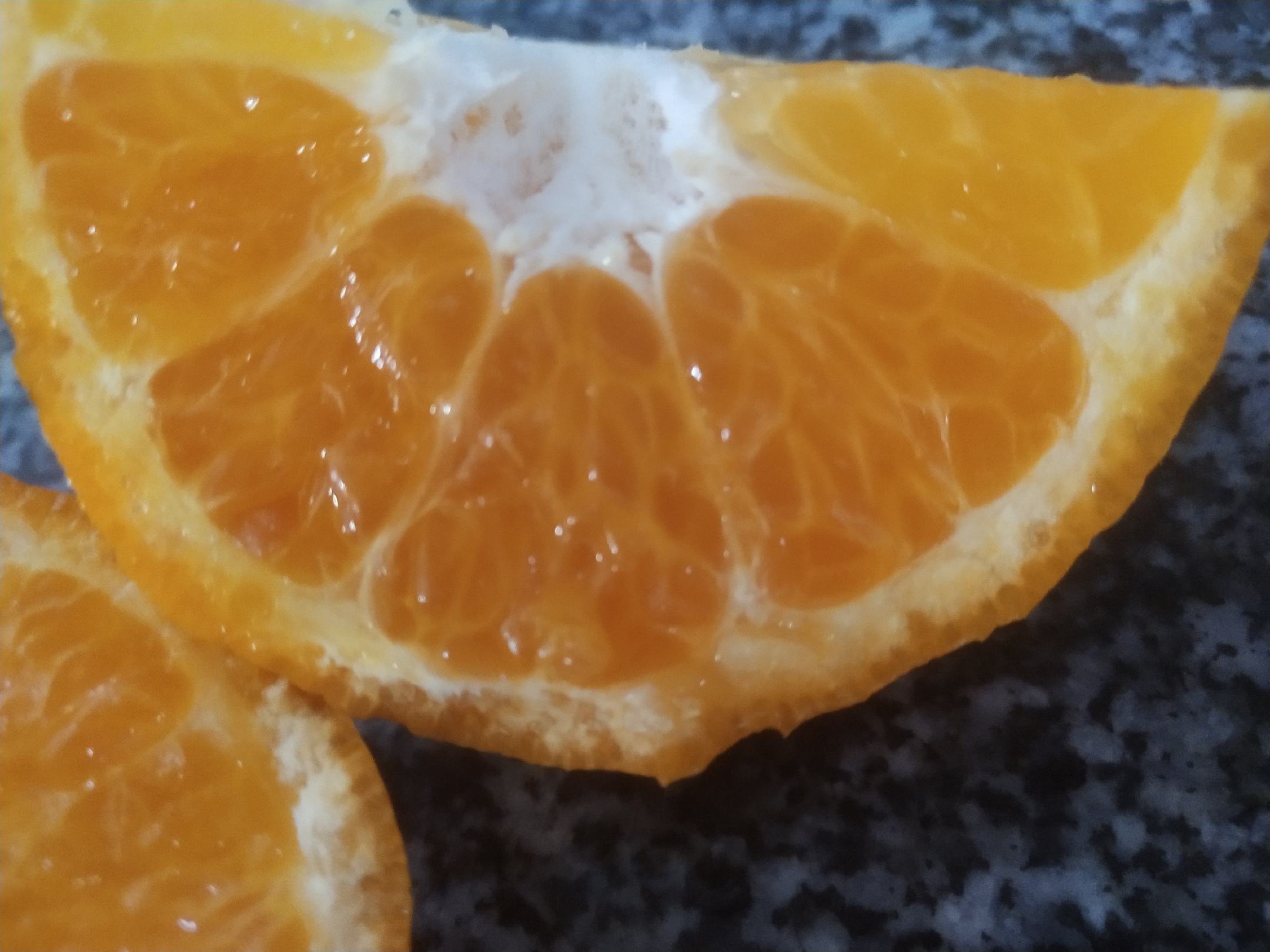 专业食品摄影视角的春见横切剖面图:精准展现其宽皮橘标志性结构——囊瓣数量适中(10–12瓣)、排列紧密而独立;果肉呈明亮橙红色,质地细腻均匀;囊衣厚度不足0.3mm,高度透明,无纤维感;无可见白色橘络附着,体现‘无渣易食’特性;背景纯白凸显洁净感,散落橘络与橘皮强调天然属性 春见柑桔剖面图:果实横向切开,呈现10–12瓣整齐饱满的橙红色囊瓣,果肉晶莹透亮,汁液隐约可见,囊衣极薄近乎透明,无明显白色经络残留,背景为纯白陶瓷盘,边缘散落2–3粒完整橘络与半片新鲜橘皮