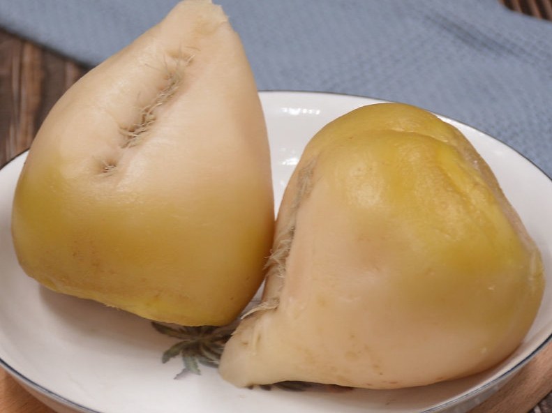 葛根咸菜成品摆盘,色泽微黄,搭配辣椒和蒜片 葛根咸菜成品展示