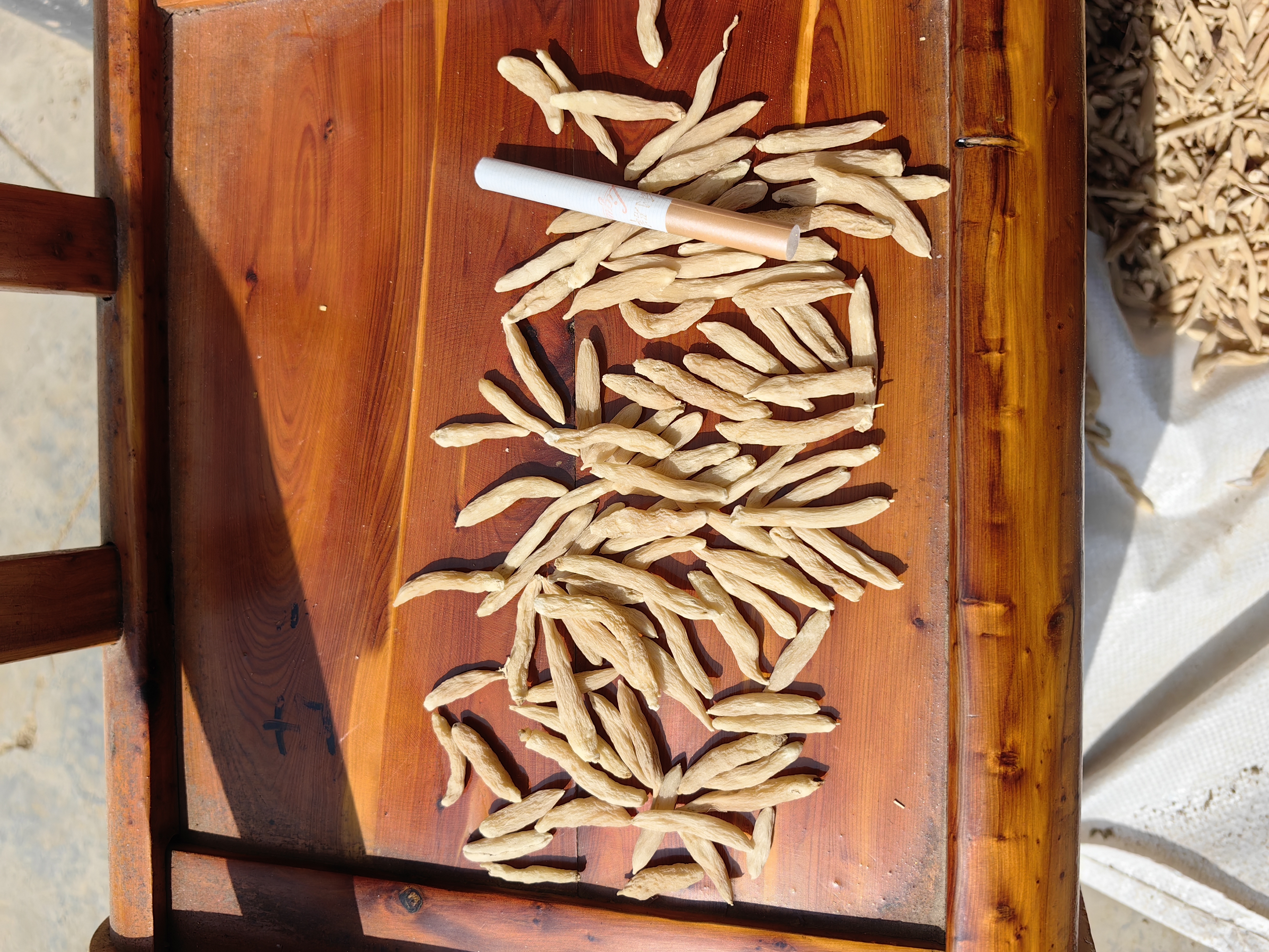 北沙参与麦冬原材料展示,摆放整齐,背景为木质桌面,突出自然质感 北沙参与麦冬原材料展示