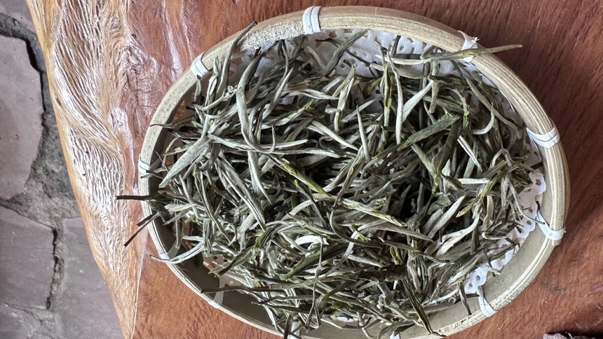现代化茶厂妃子笑精制产线:低温提香工序特写,不锈钢滚筒式提香机运行中,环境温湿度恒控(22℃/65%RH),操作台摆放3组对比样(未提香/115℃提香/120℃提香),凸显工艺对毫香保留的关键影响 妃子笑春茶精制车间实景,工人正在操作低温提香机,设备显示屏显示温度114.8℃、时间17分42秒,工作台上整齐码放银毫显露的干茶样品