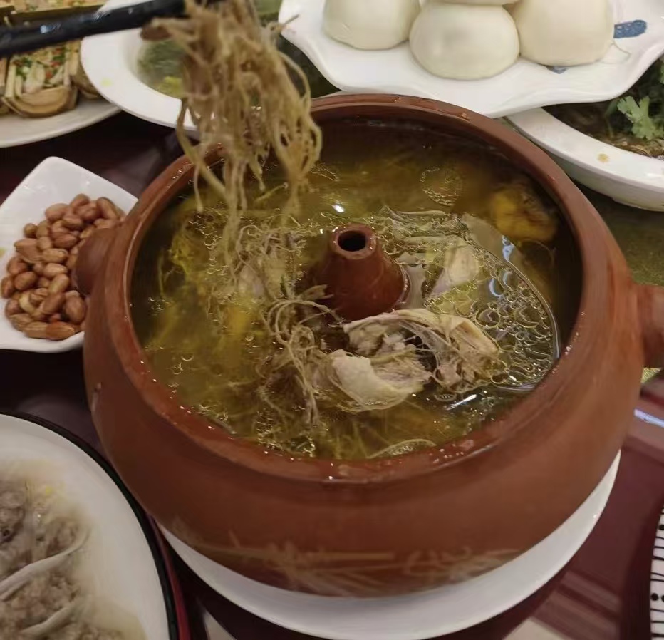 一锅热气腾腾的三七炖鸡汤,配有切片三七和鸡肉的组合 三七炖鸡成品图