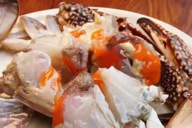 高清特写:刚出盐焗的远海梭子蟹平铺竹匾,蟹壳呈琥珀红润色,蟹黄丰腴金黄并微微渗出脂油,周围散落微黄炒香盐粒,展现‘盐h’工艺带来的视觉与质感双重高级感 盐h梭子蟹出锅特写:金红蟹壳泛油光,蟹黄饱满凸起,竹匾底衬粗盐粒