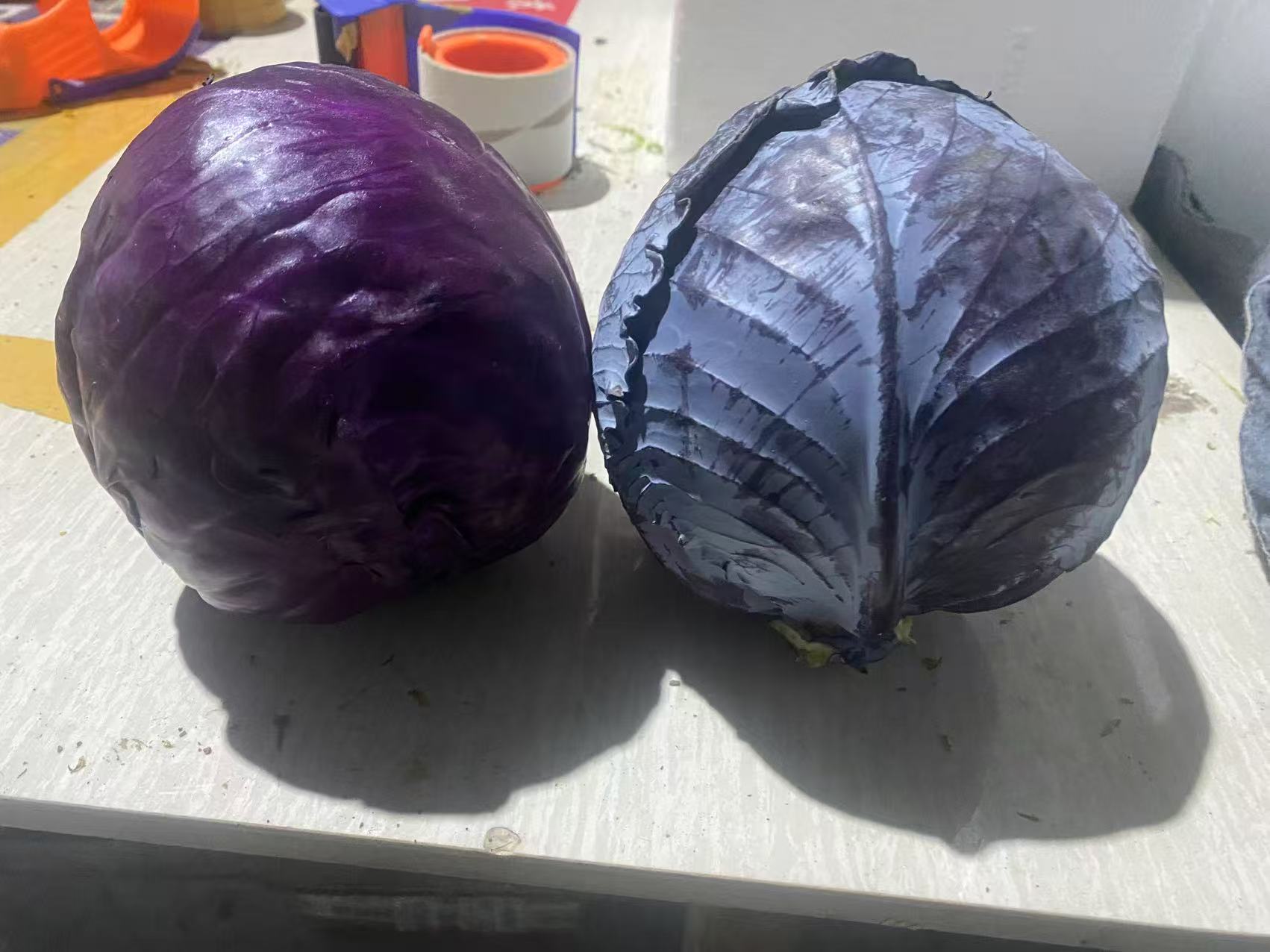 一颗完整的绿甘蓝摆放在木质案板上,外层叶片为鲜绿色,层层包裹形成紧实的球形,背景虚化,光线柔和,突出蔬菜的新鲜质感 绿甘蓝整颗展示图