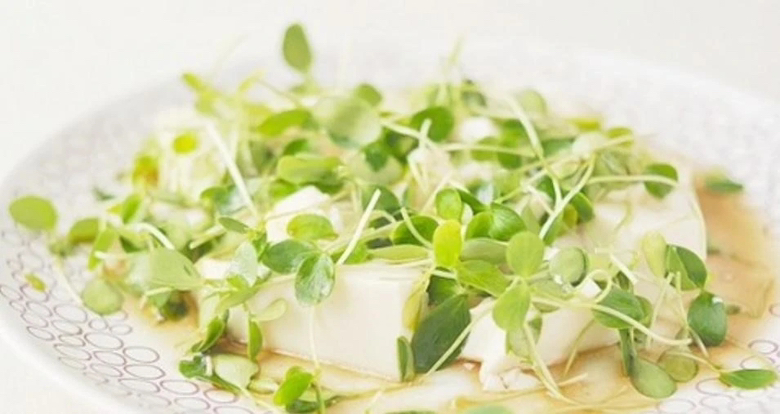 一盘精致的凉菜,主料为翠绿色的香椿碎与浅绿香芹段,混合乳白色豆腐干丁,表面淋有光泽的香油,撒有少量蒜末,摆盘清新自然,体现健康饮食风格 香椿香芹拌豆腐干成品图