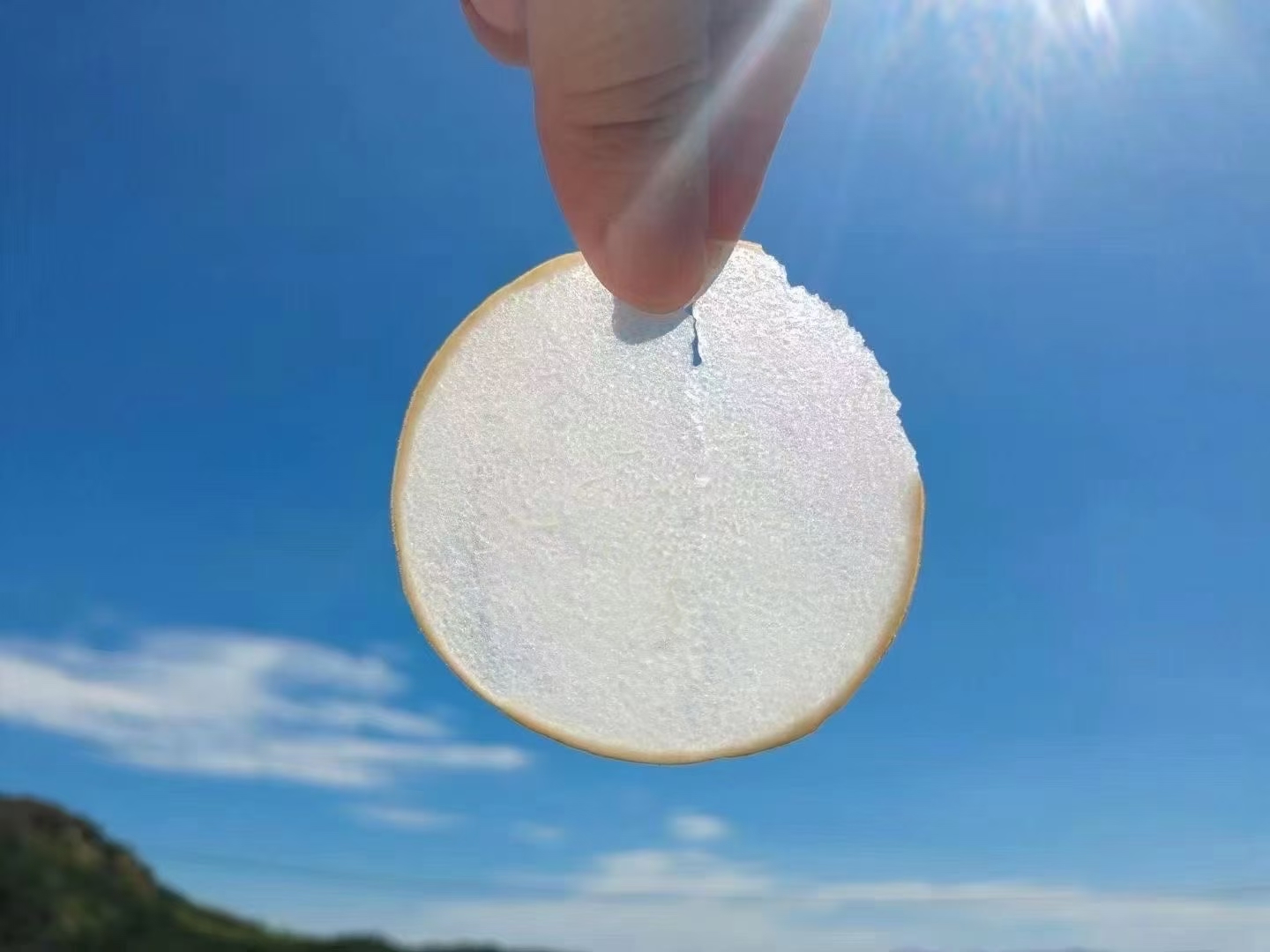 水晶梨冻成品特写：淡金琥珀色冻体完整置于玻璃方盒中，表面光滑如镜，无气泡无裂纹，边缘清晰锐利，旁边摆放一把不锈钢薄刃刀与两片新鲜桂花